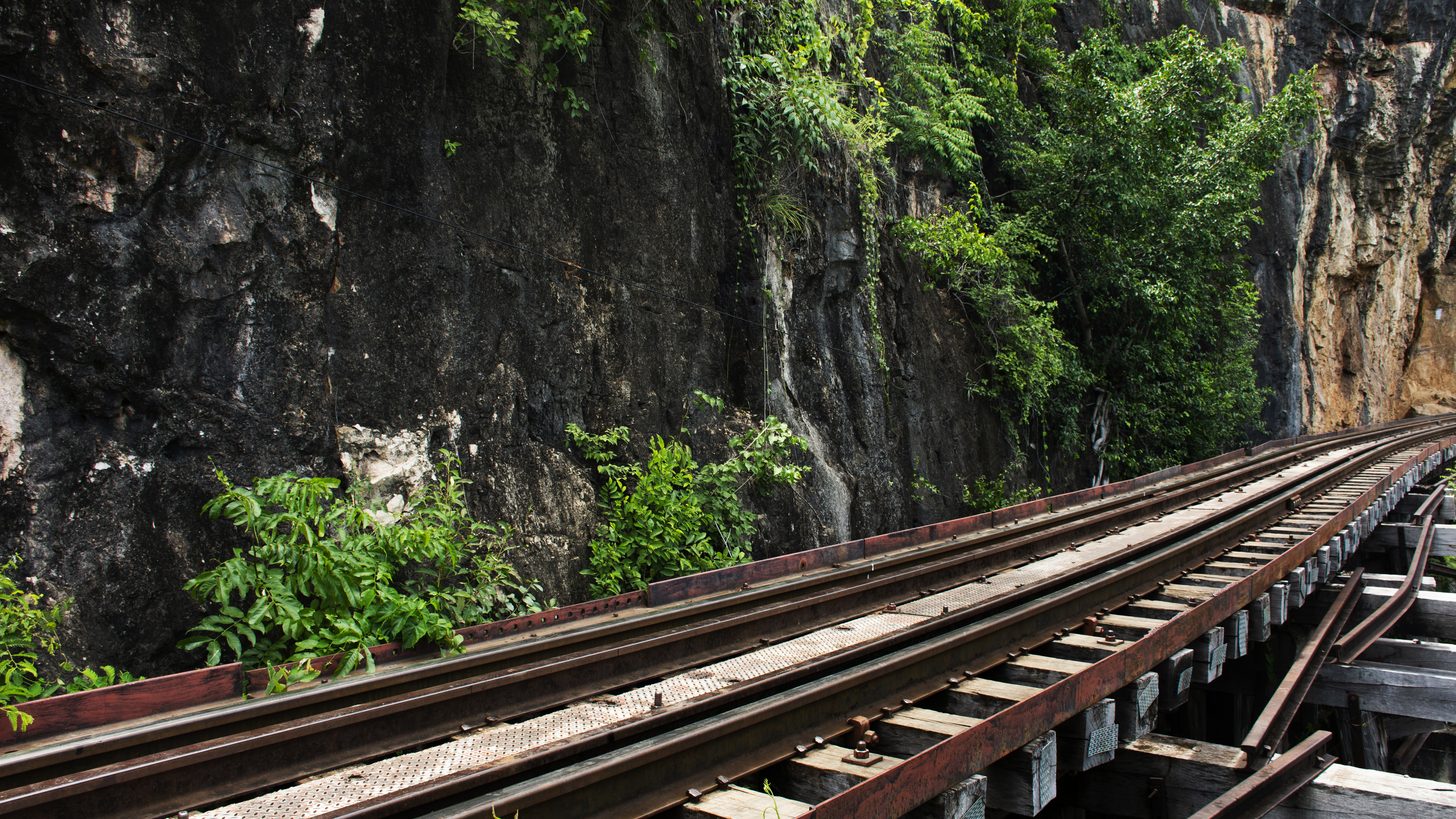 The wooden Death Railway trestle hugging a cliff along the River Kwai