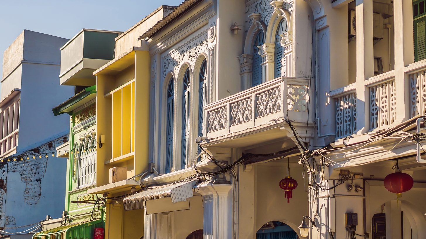 A row of restored Sino-Portuguese shophouses in Phuket Old Town in late afternoon light