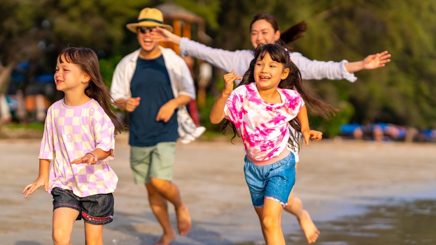 A family walking together on a tropical beach at sunset