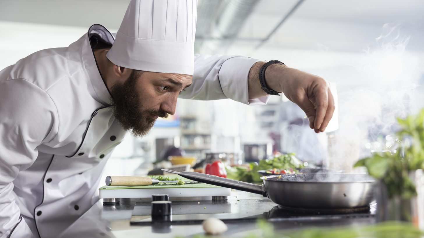 A chef garnishing a fine-dining plated dish