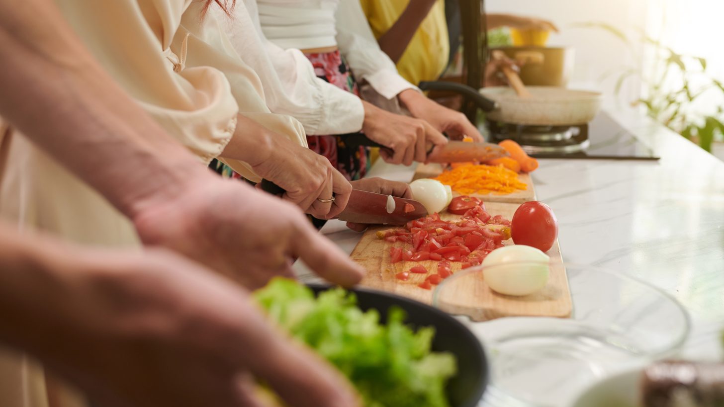Travellers chopping vegetables together at a Thai cooking class