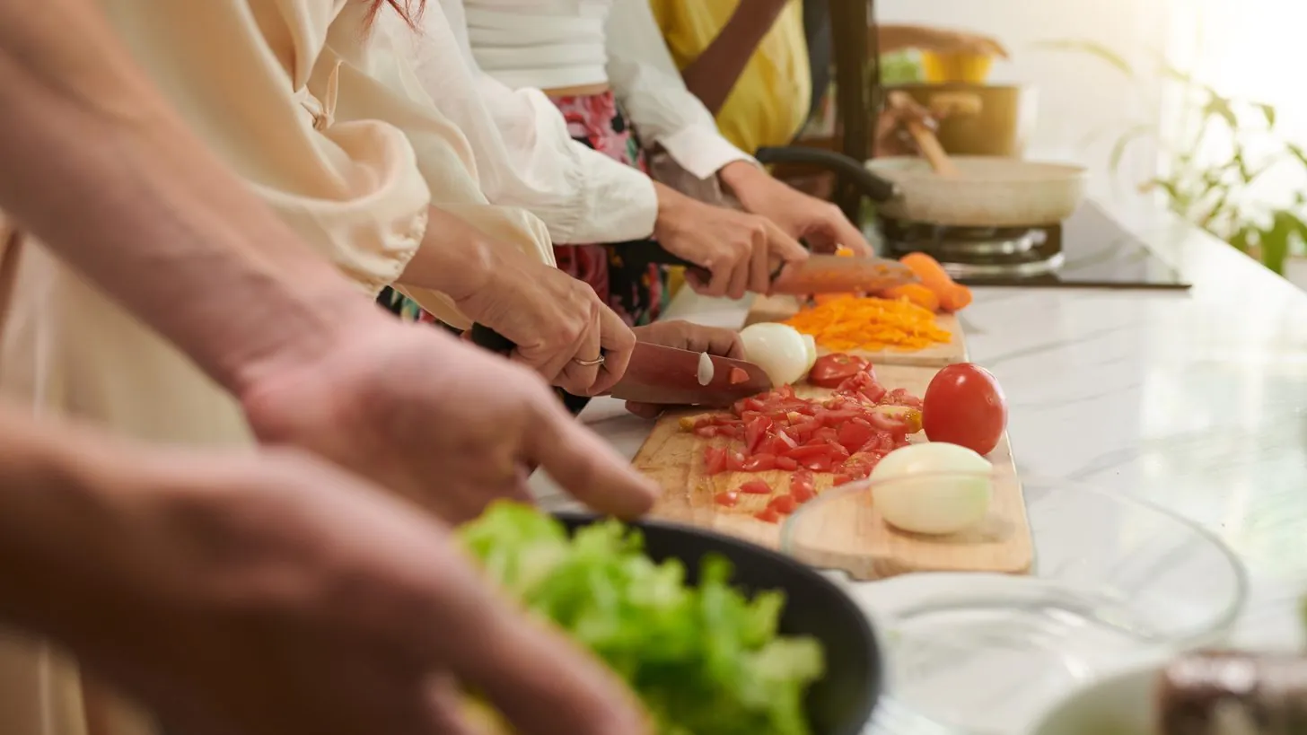 Travellers chopping vegetables together at a Thai cooking class
