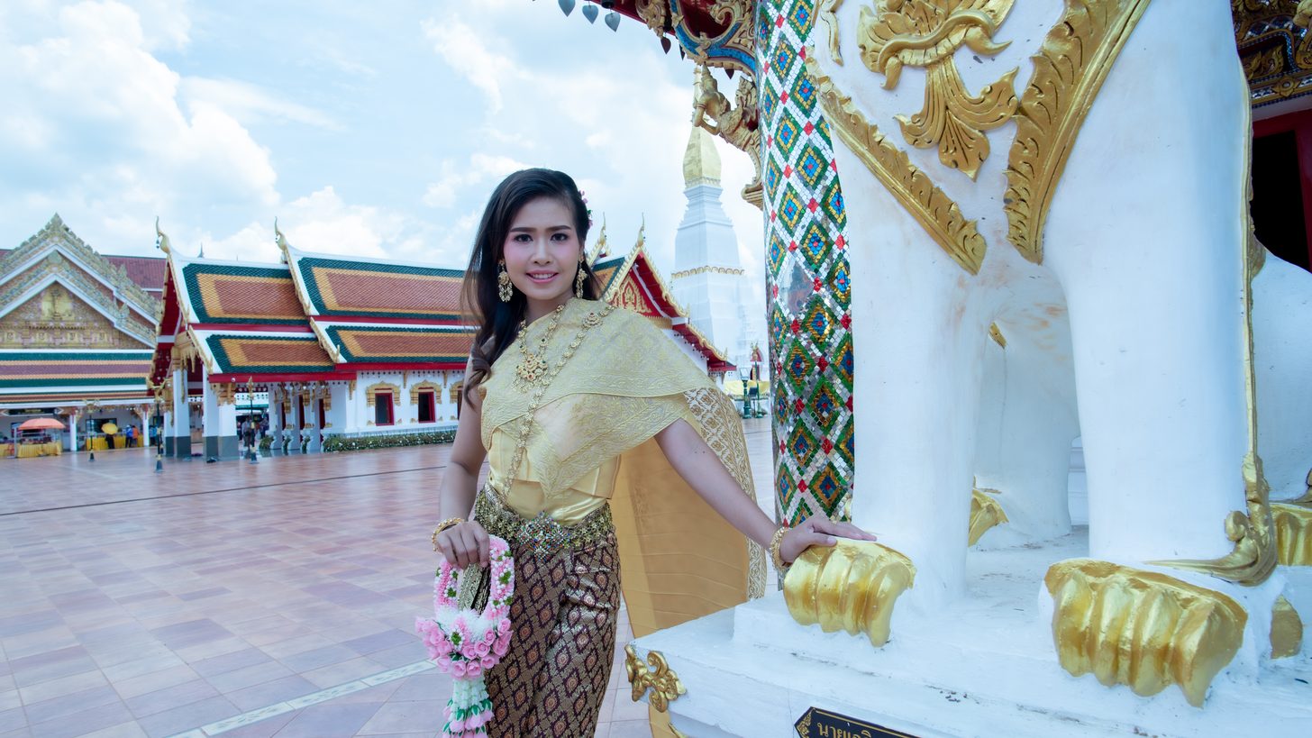 A woman in traditional Thai dress at a Buddhist temple in Thailand