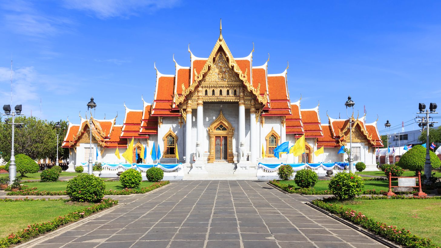 Accessible ramp and level pathway leading toward a Thai temple courtyard