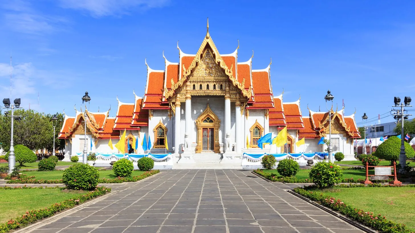 Accessible ramp and level pathway leading toward a Thai temple courtyard