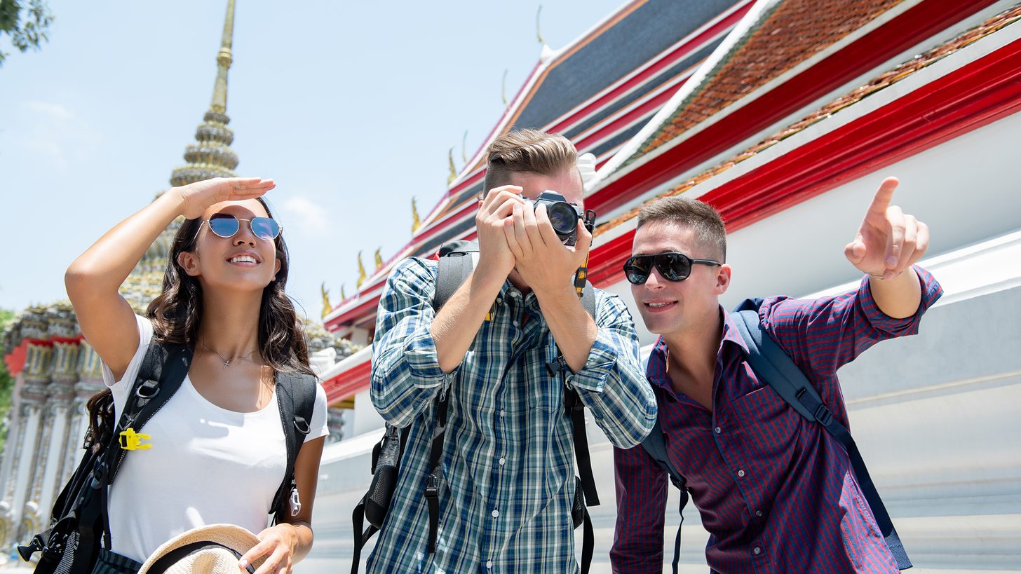 Small group of travelers together at a temple in Bangkok, Thailand