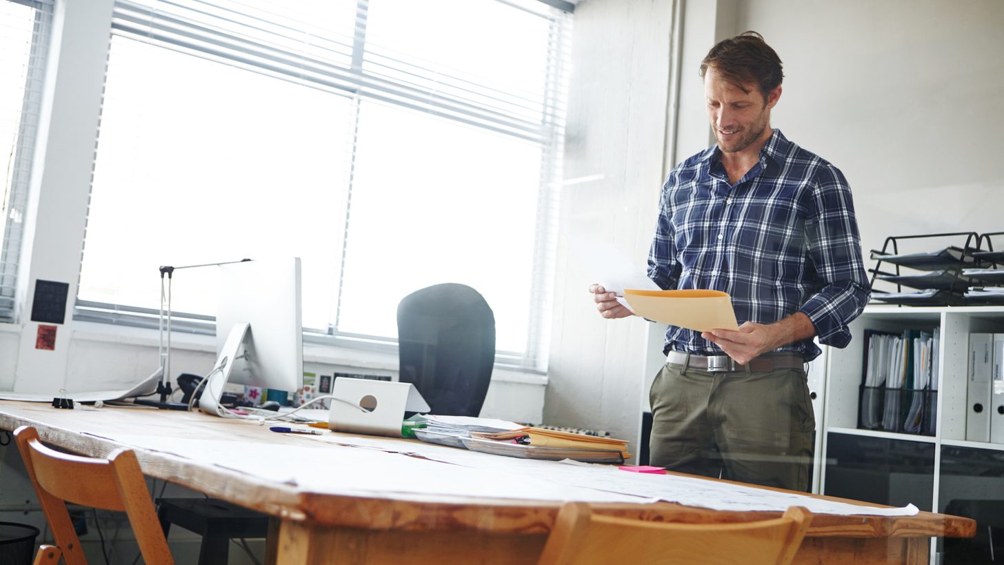 Ground team member reviewing group logistics documents in a file folder