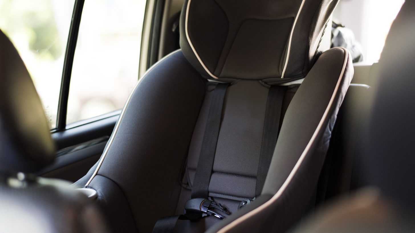Infant car seat properly fitted in the back of a private transfer vehicle in Thailand