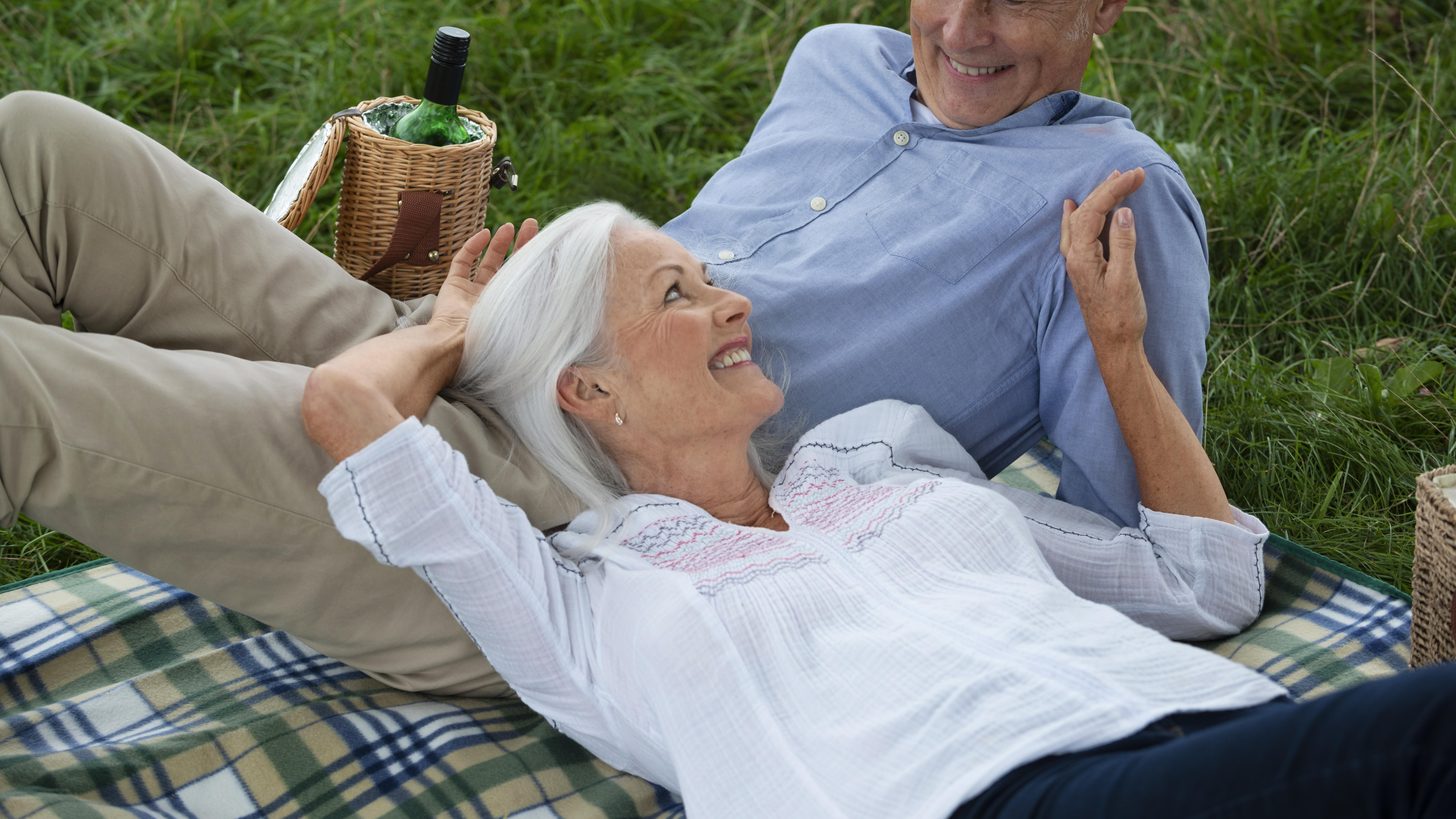 Two senior travellers relaxing outdoors together on a trip