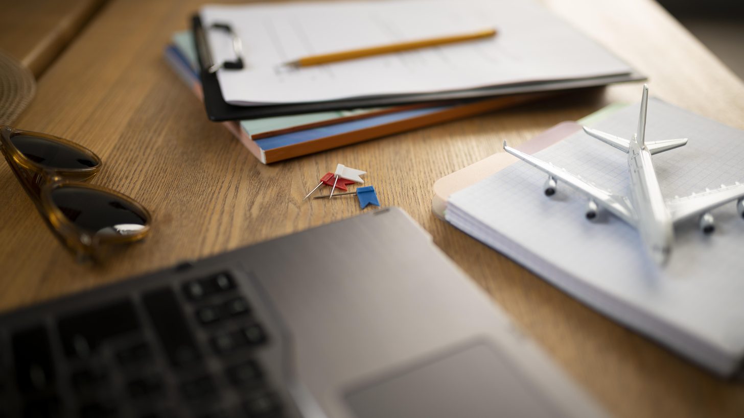 Travel insurance documents and a passport laid out beside a laptop while planning a Thailand trip