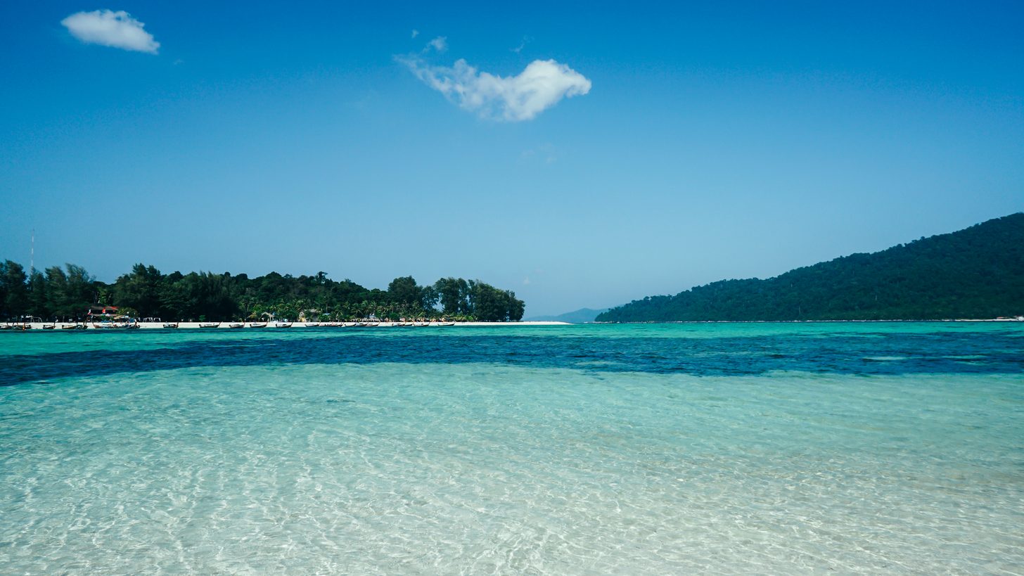 Quiet empty beach on a lesser-known Thai island with clear turquoise water