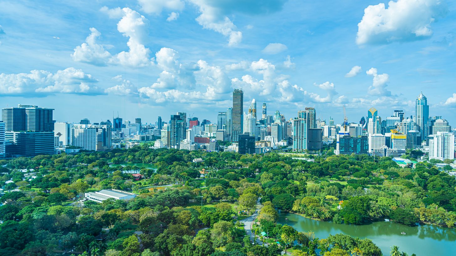 Green park space surrounded by Bangkok high-rise buildings