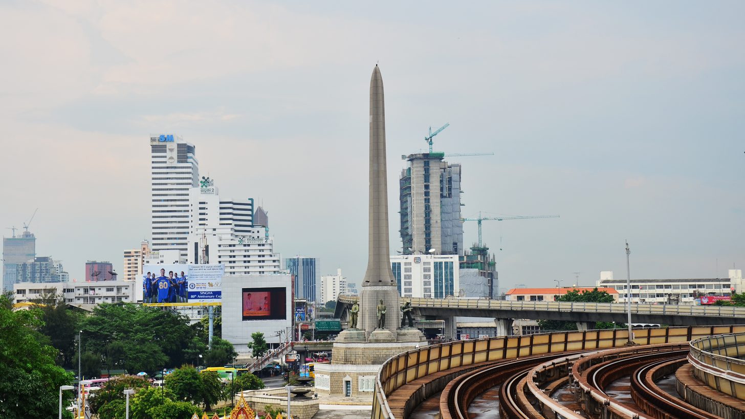Elevated rail line running between buildings in a Bangkok district