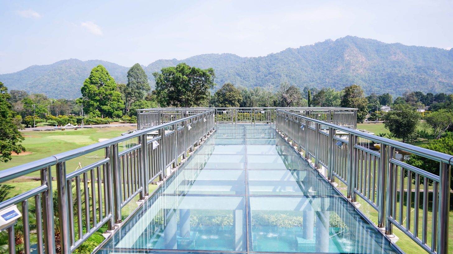 Glass-floored skywalk bridge with views over green countryside