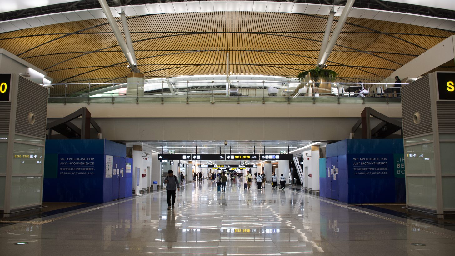 Modern airport terminal interior with travellers at check-in