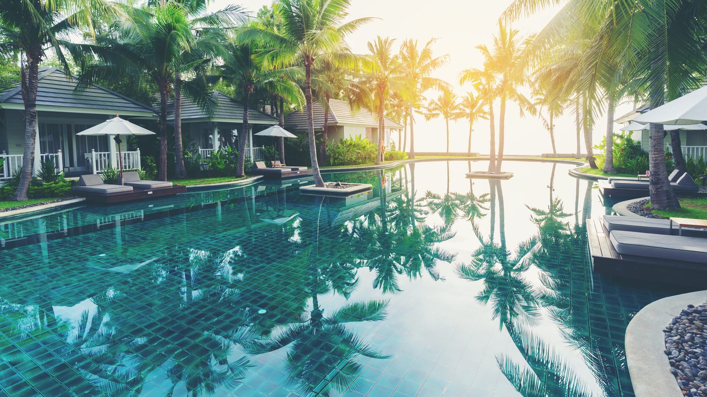 Private pool villa with sun loungers surrounded by tropical greenery