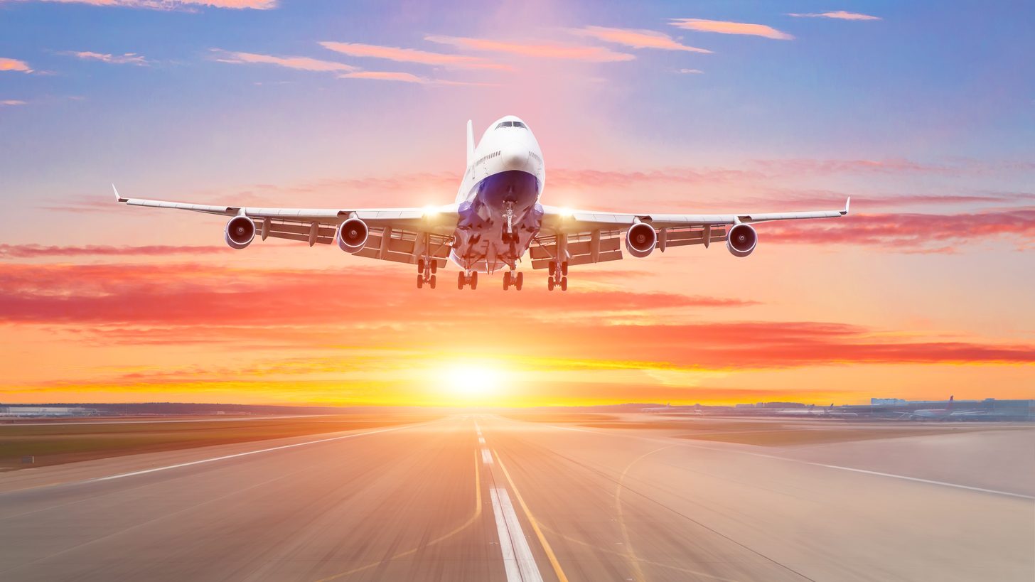 Wide-body aircraft taking off into a warm evening sky