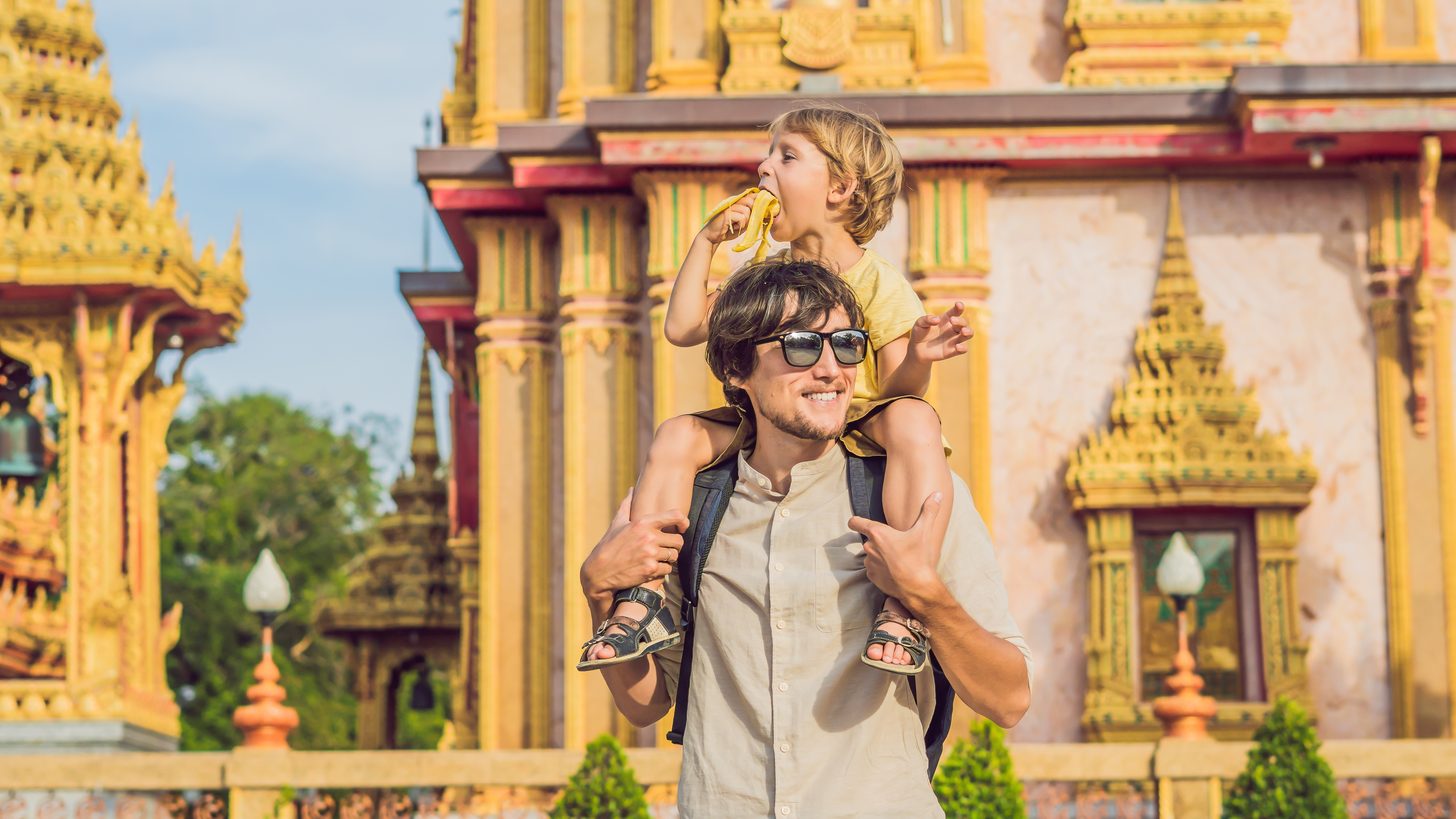 A parent and child visiting an ornate Thai temple