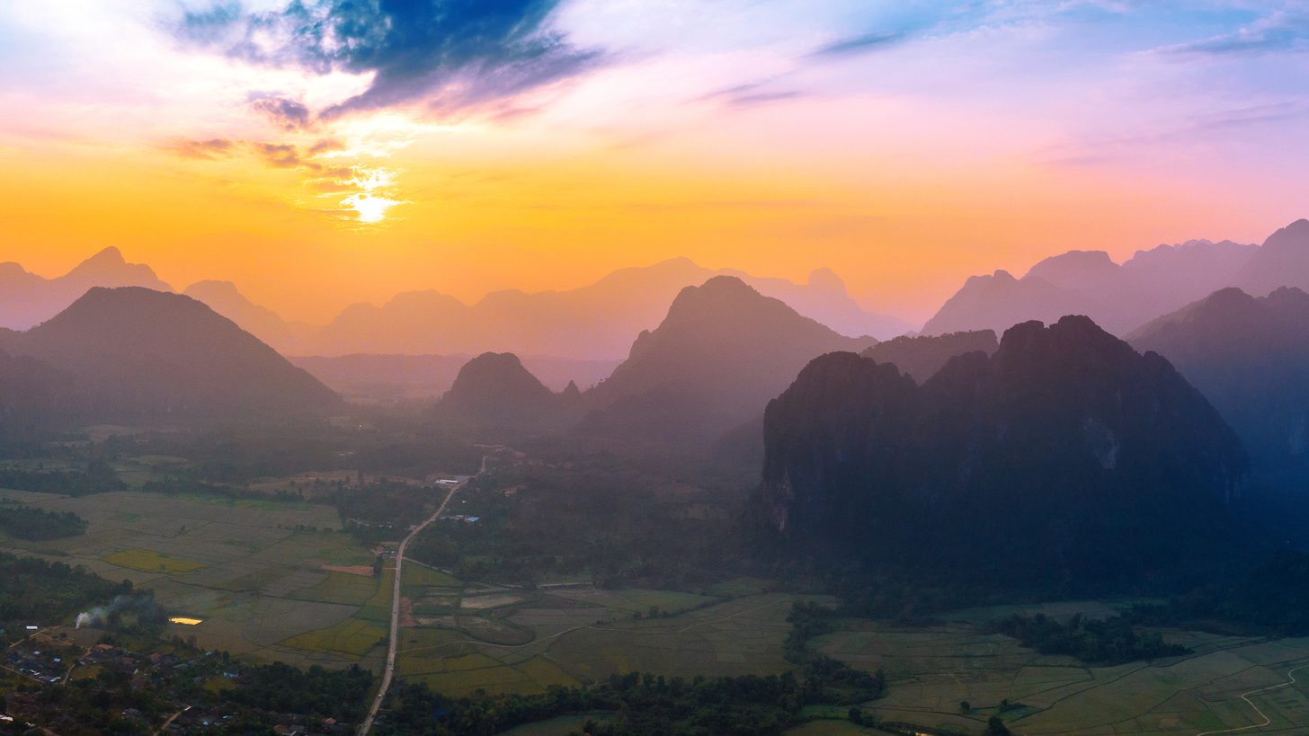 Aerial view over a misty valley and mountains at golden hour