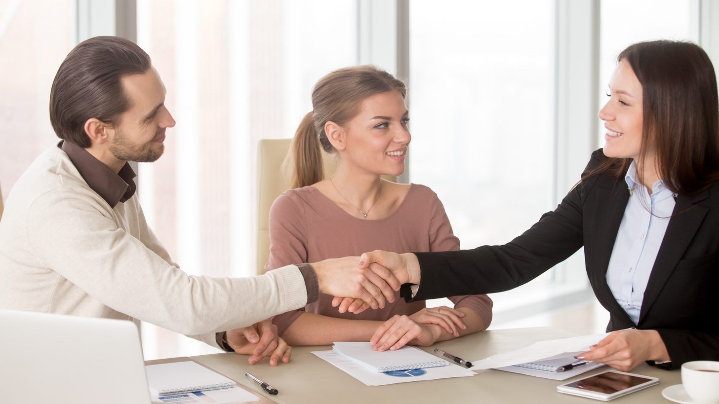 Business people shaking hands across a table after an agreement