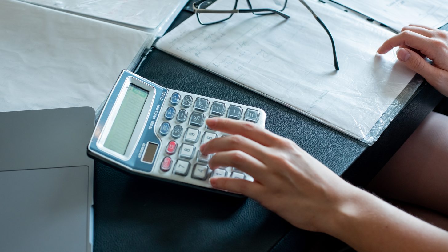 Hands reviewing itemised invoices and documents at an office desk