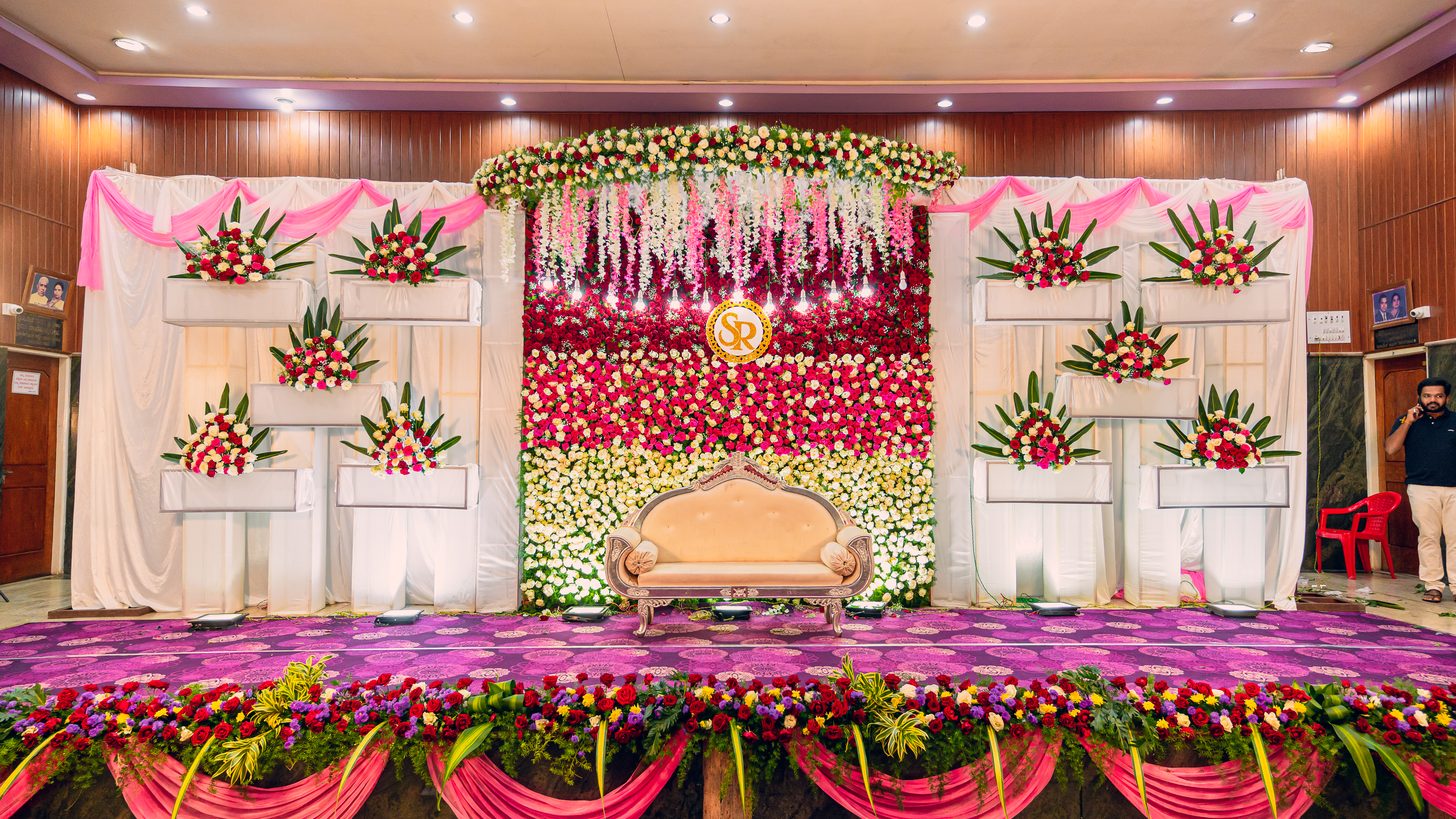 A floral wedding stage with a decorated backdrop