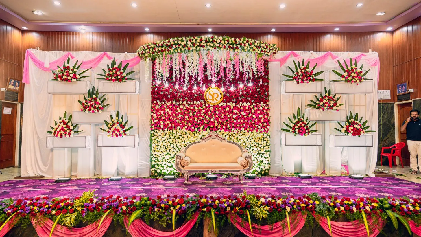 Eine blumengeschmückte Hochzeitsbühne mit dekoriertem Hintergrund