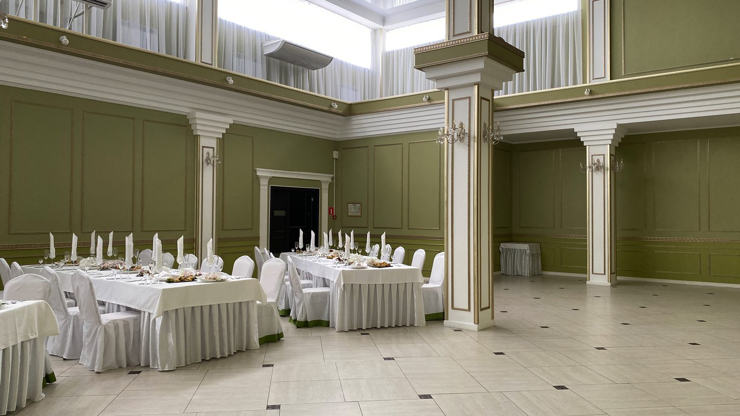 An empty banquet ballroom with round tables and high ceilings