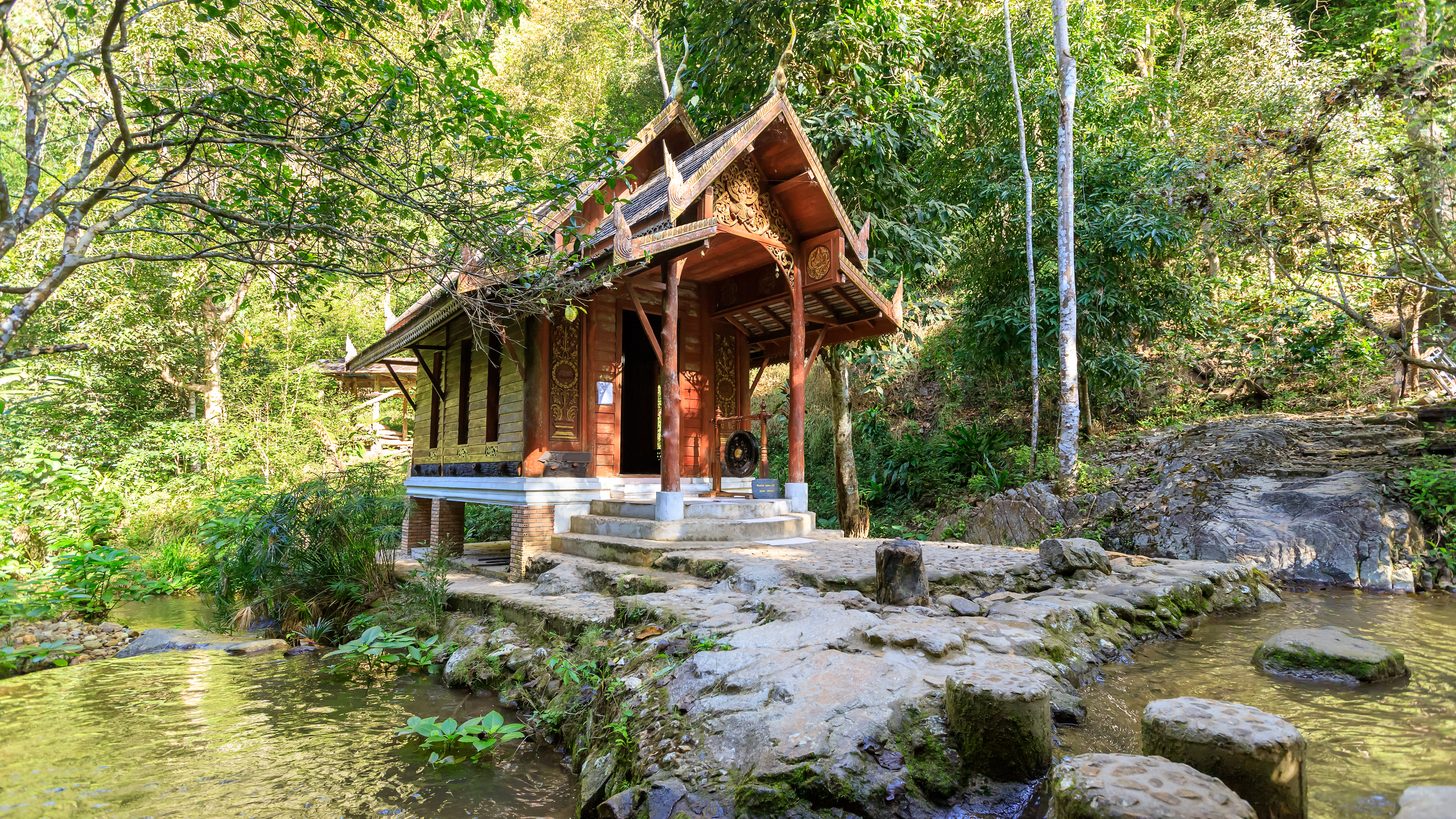 A riverside chapel among trees in a Chiang Mai hill village