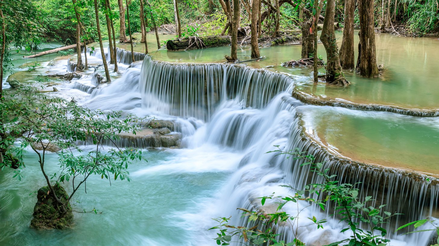 Turquoise emerald pool beneath a jungle waterfall tier at Erawan