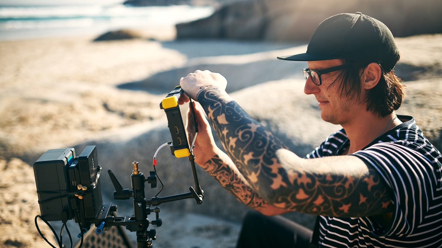 A film crew with professional camera equipment shooting on a Thai beach at sunset