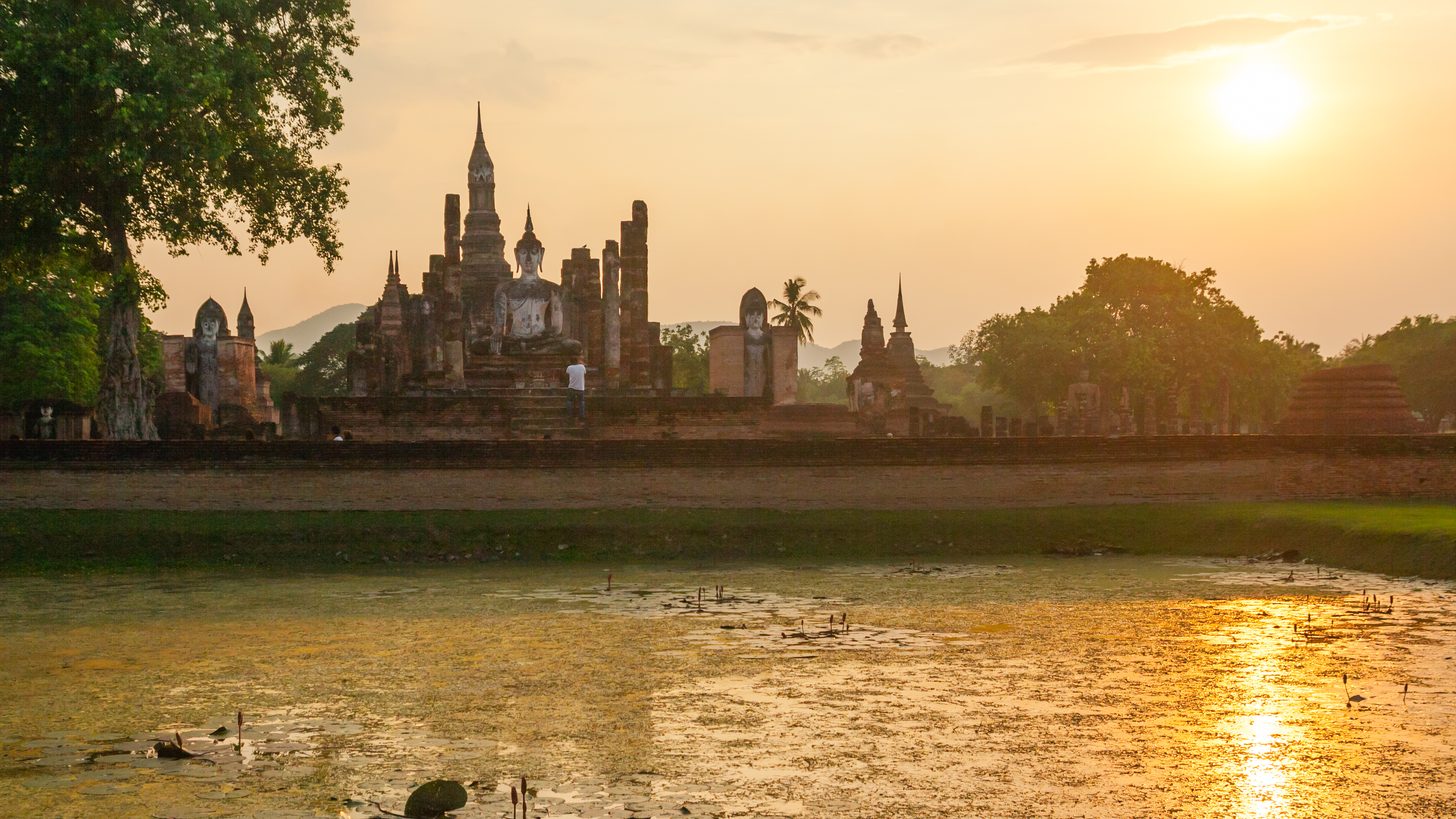 Ancient Buddha statue and temple ruins at a Thai historical park