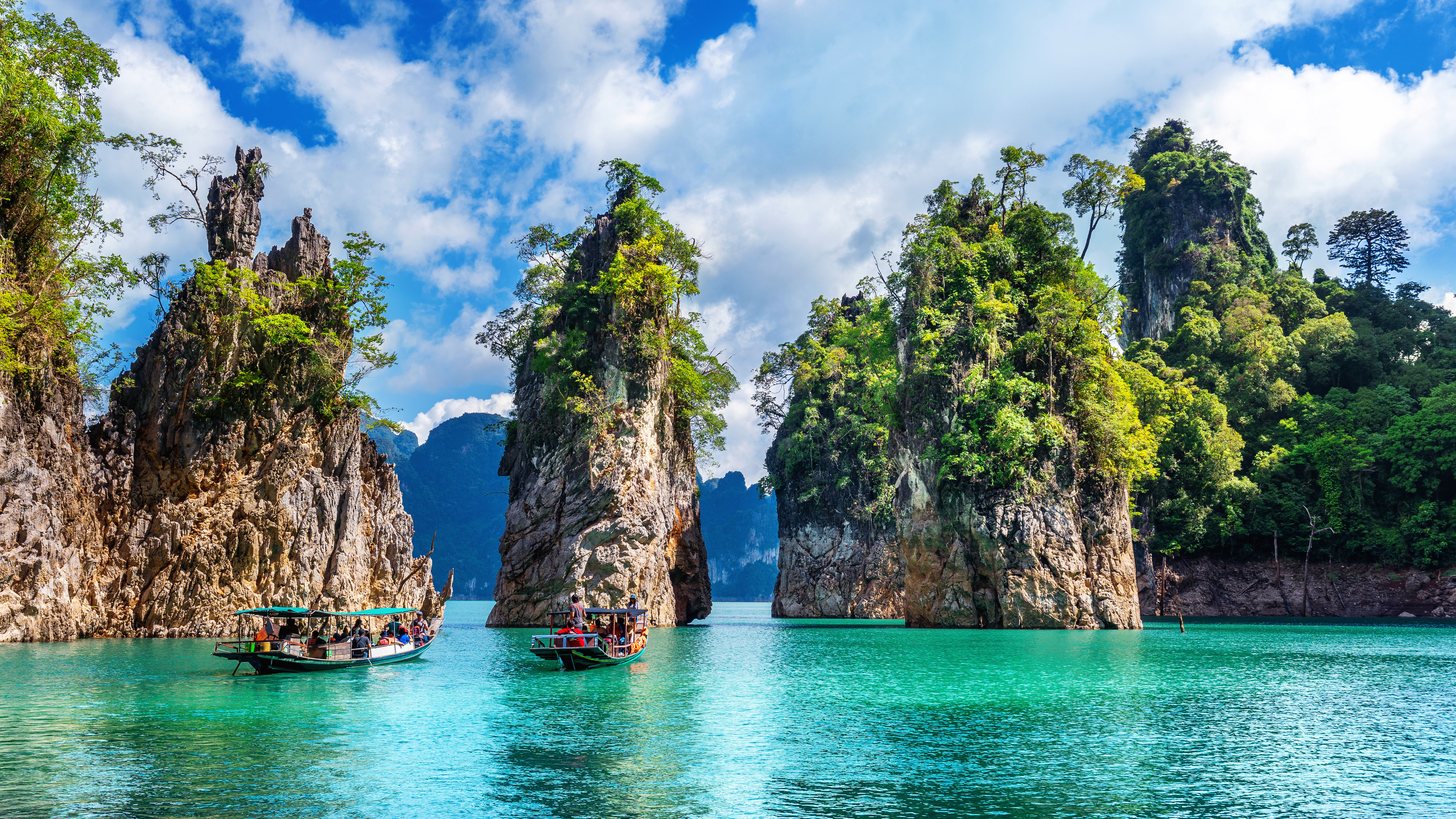 Limestone karst mountains rising from the still water of Ratchaprapha Dam in Khao Sok National Park, Surat Thani