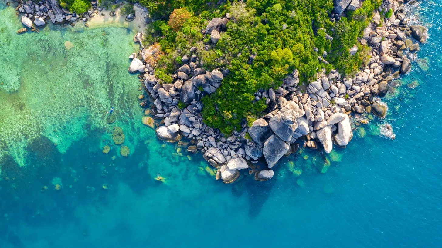 Luftaufnahme der Küstenlinie und der flachen Riffplatten der Insel Koh Tao an Thailands Golfküste