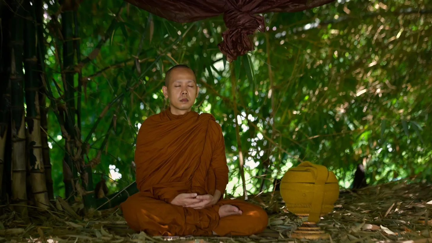 พระสงฆ์นั่งสมาธิในความสงบของลานวัดเก่าแก่ในประเทศไทย