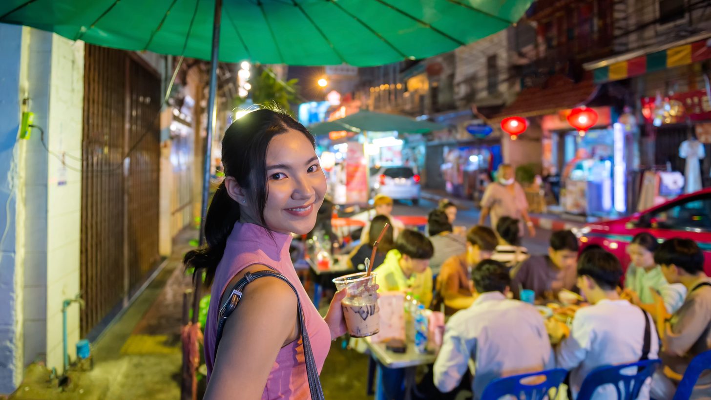 夜色中，合艾一条热闹的市场街上亮着灯的街边小吃摊