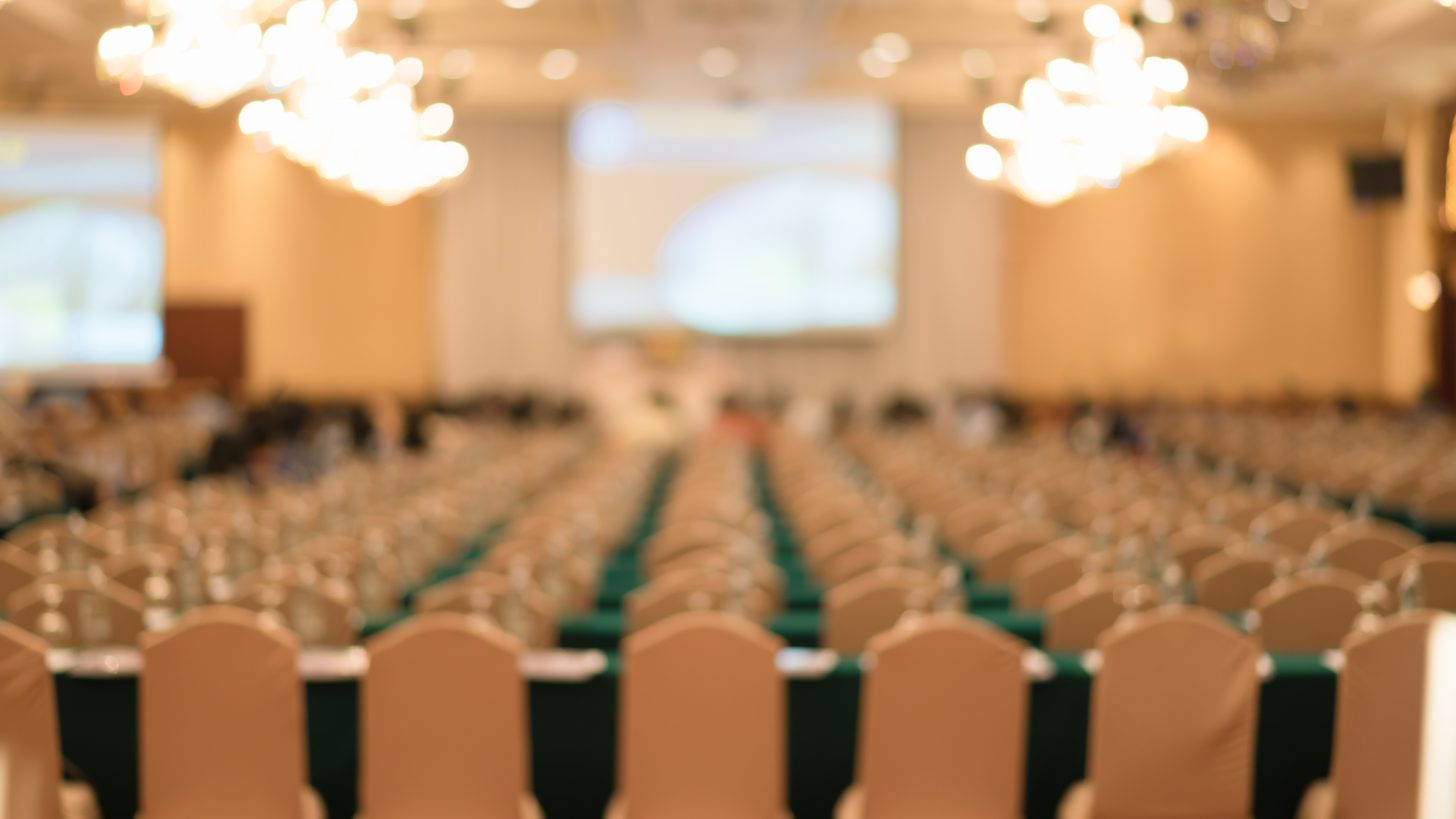 Delegates seated in a large conference hall during a session