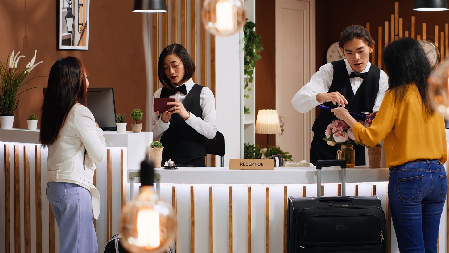 Travellers checking in at a hotel reception desk