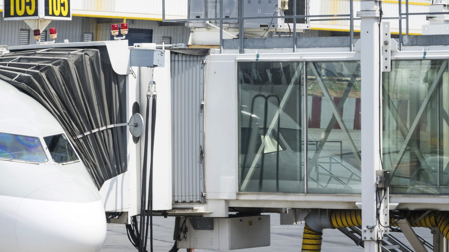 A boarding bridge connected to a parked airliner