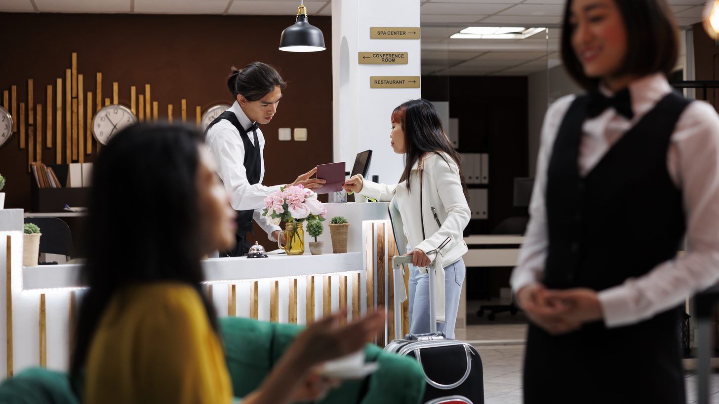 Hotel front-desk staff assisting arriving guests at a resort reception