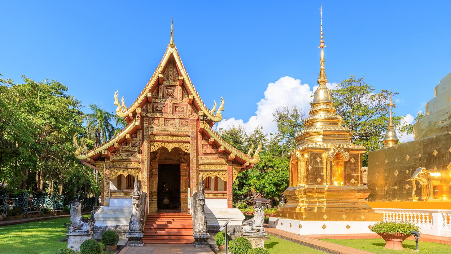 A golden Lanna pagoda and temple chapel in northern Thailand