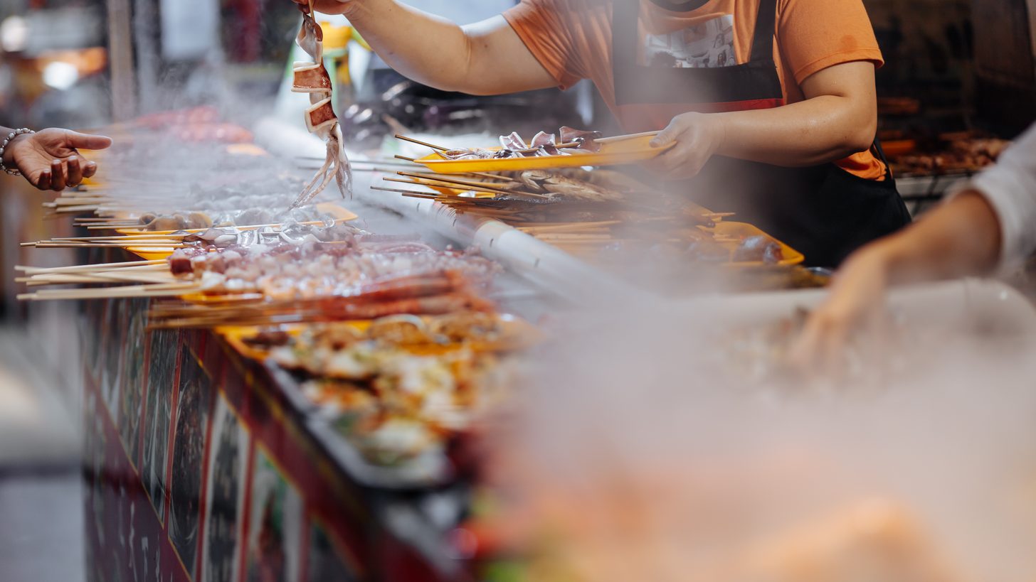 Grilled seafood laid out across a busy market stall