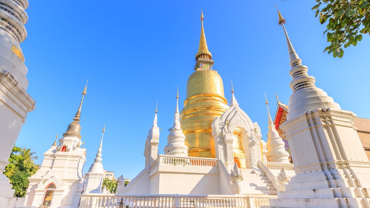Pagodas at a temple in Chiang Mai under a clear sky