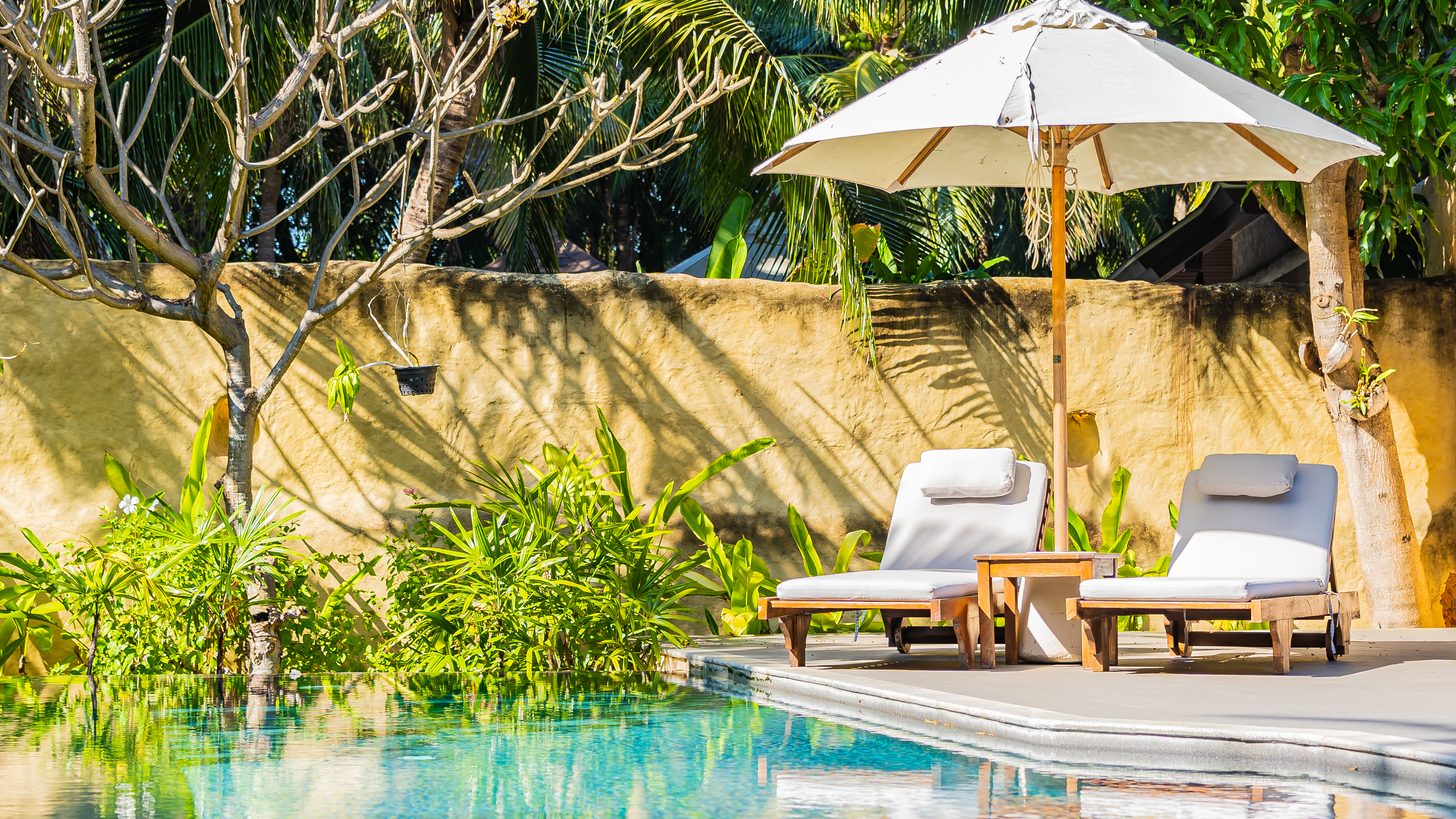 Loungers and an umbrella beside a quiet hotel pool