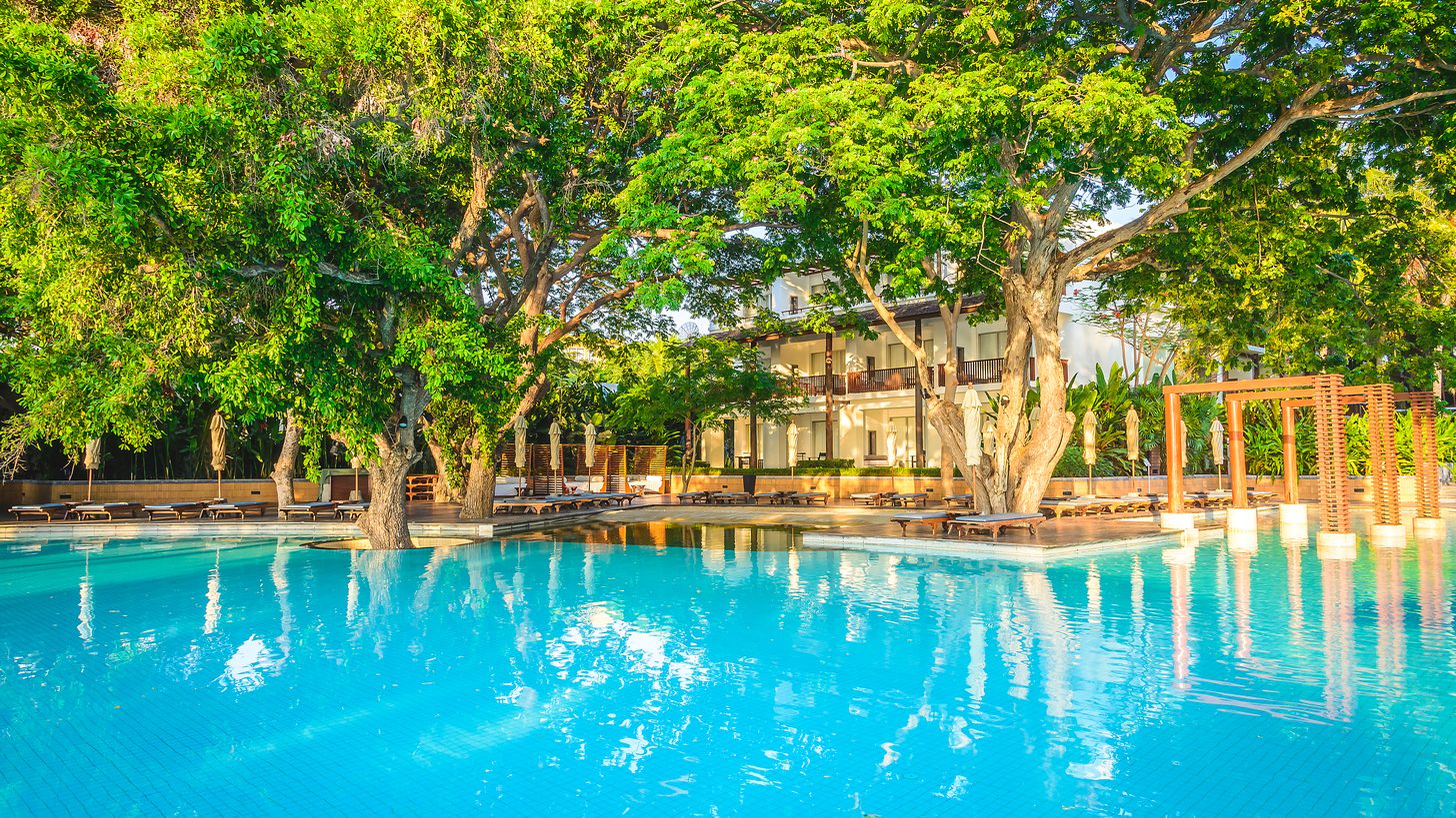 A quiet resort swimming pool with empty loungers