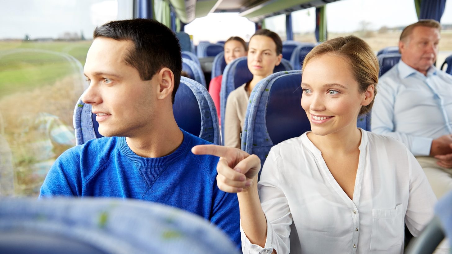A group of travellers seated together on a tour vehicle