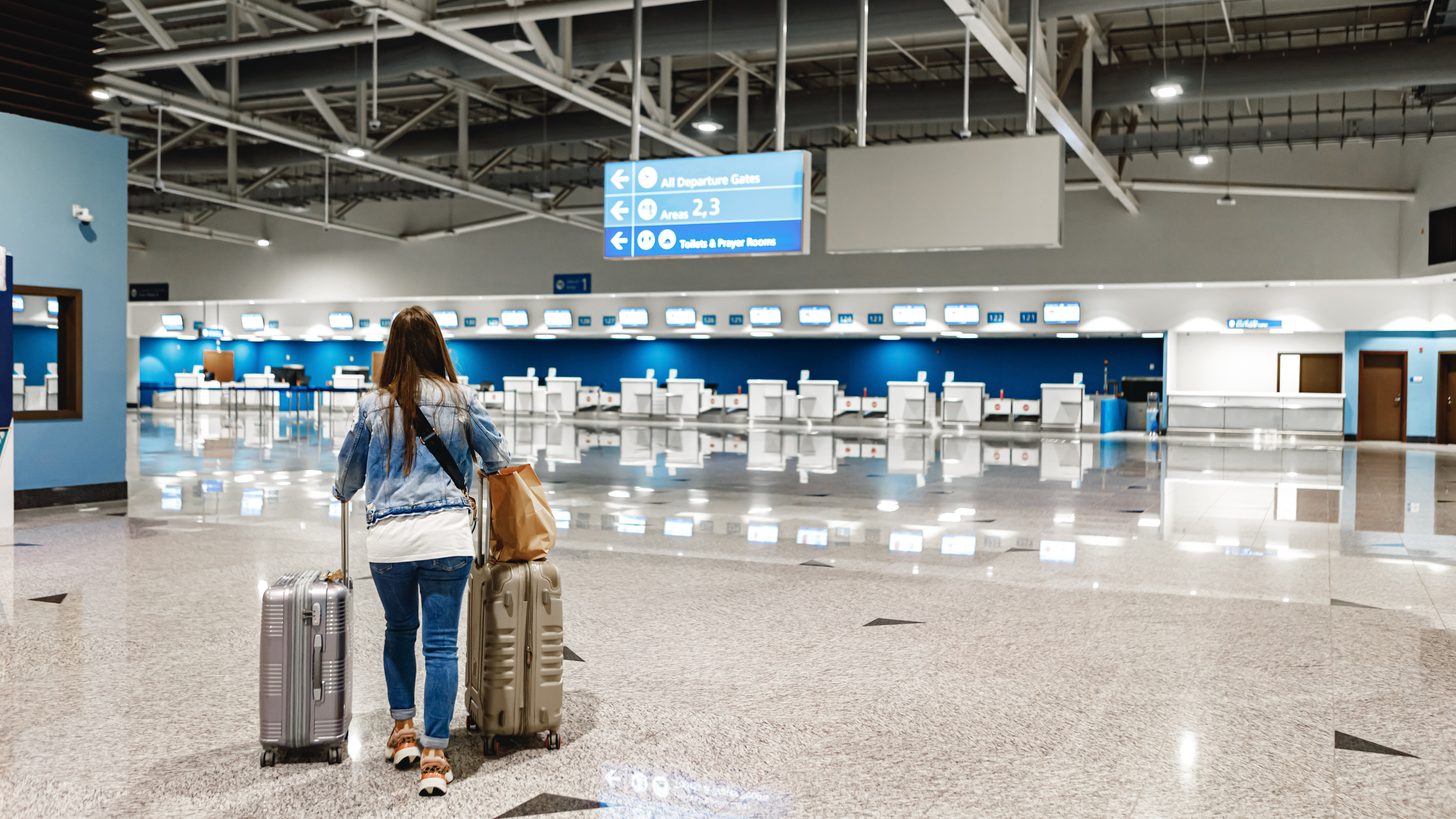 Travellers with luggage moving through an airport arrivals terminal