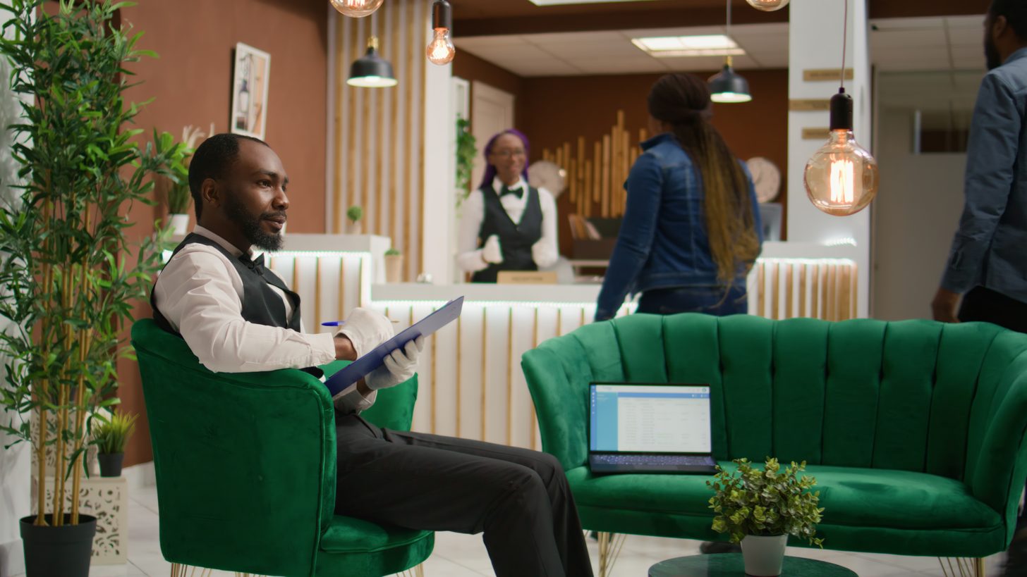 A hotel employee reviewing booking records on a screen