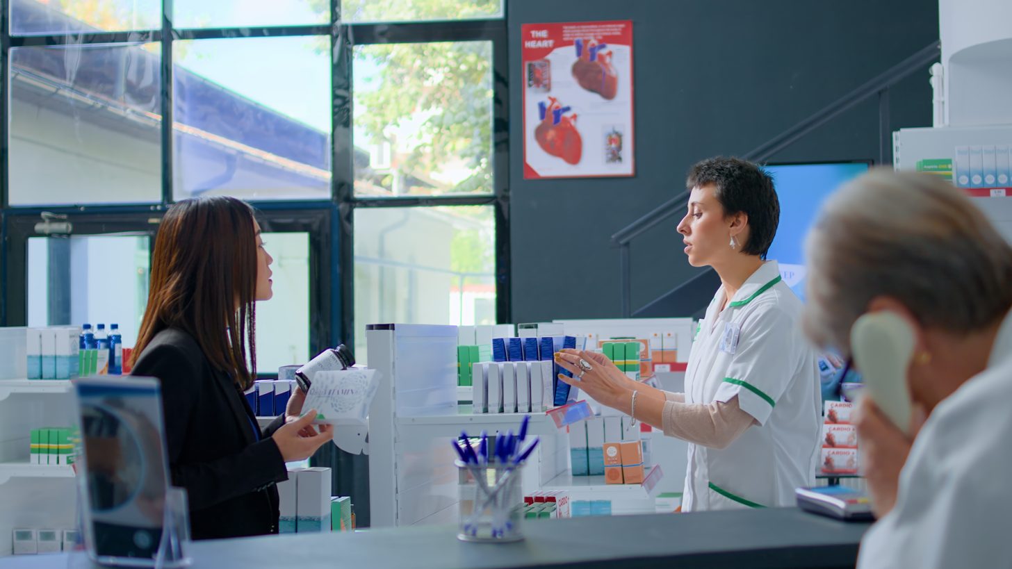 A pharmacist behind the counter of a Thai pharmacy