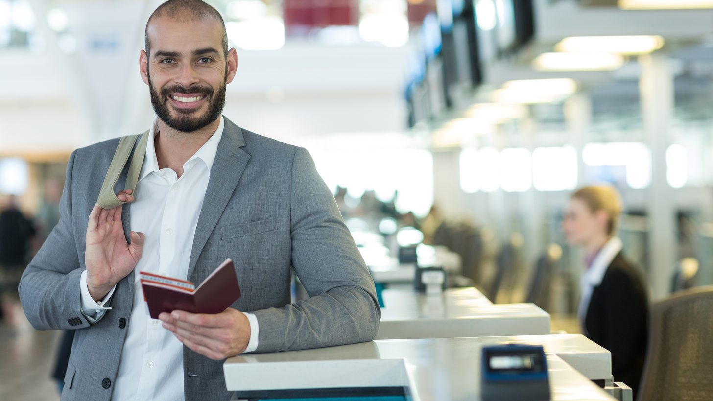 A traveller presenting a passport and boarding pass at an airline check-in counter